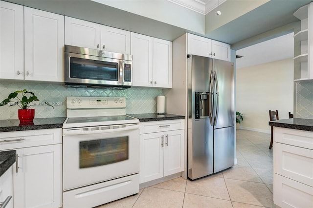 kitchen featuring appliances with stainless steel finishes, ornamental molding, light tile patterned floors, backsplash, and white cabinets