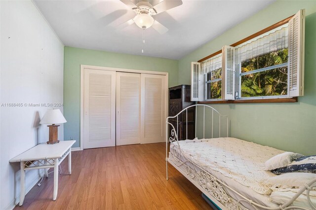 bedroom with light hardwood / wood-style flooring, ceiling fan, and a closet