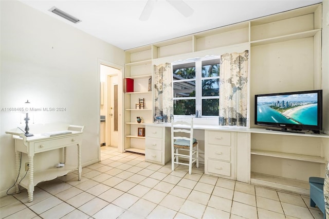 office with light tile patterned floors, built in desk, and ceiling fan