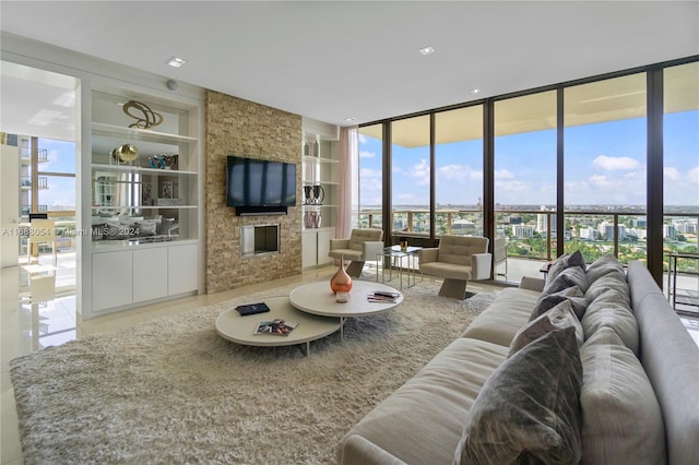 living room with a fireplace, built in features, tile patterned floors, and floor to ceiling windows