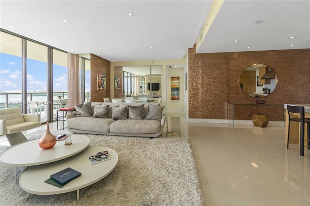 living room featuring expansive windows, a water view, and light tile patterned flooring