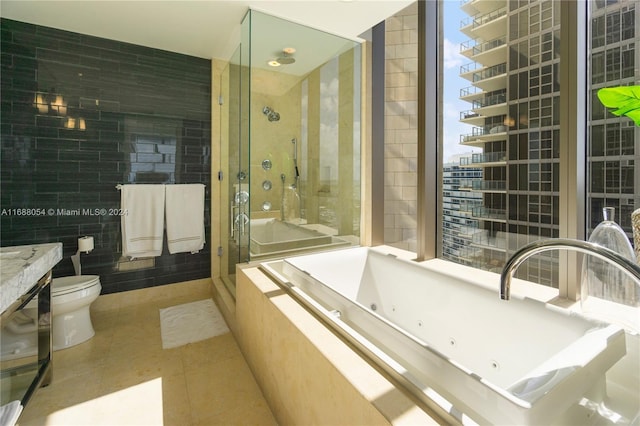 full bathroom featuring tile patterned floors, toilet, tile walls, vanity, and independent shower and bath