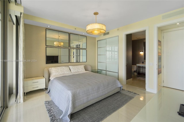 bedroom with ensuite bathroom and light tile patterned flooring