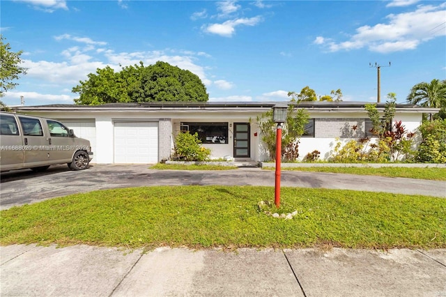 single story home with a garage and a front yard