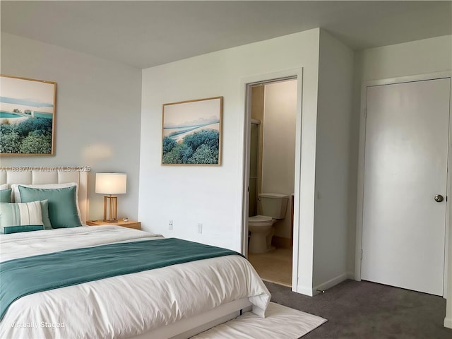 bedroom with ensuite bathroom and dark colored carpet