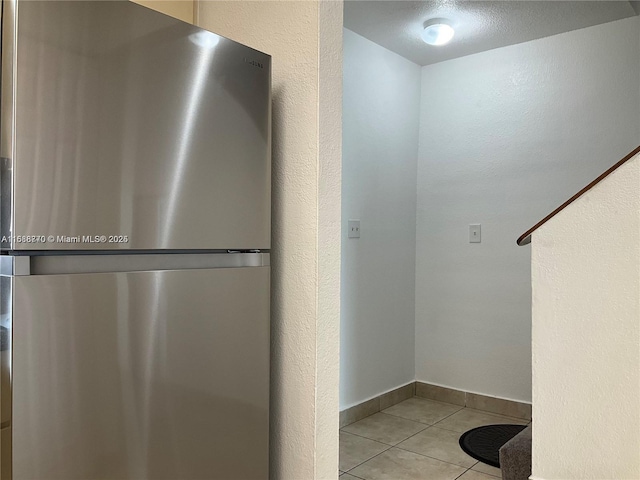 kitchen featuring stainless steel refrigerator and light tile patterned flooring