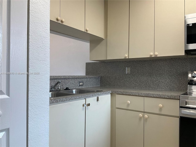 kitchen with stainless steel appliances, sink, and decorative backsplash