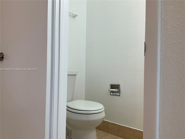 bathroom with toilet and tile patterned flooring