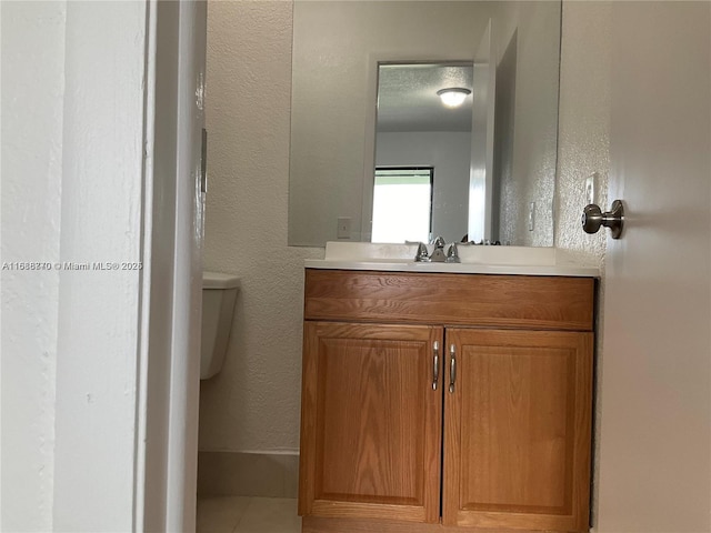 bathroom with vanity, toilet, and tile patterned flooring