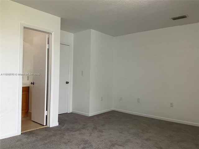 spare room with carpet and a textured ceiling