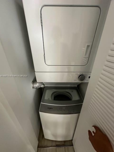 clothes washing area with stacked washer / dryer and hardwood / wood-style floors