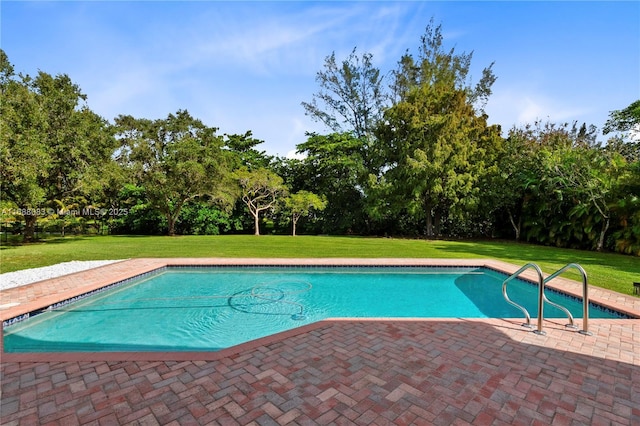 view of swimming pool featuring a yard and a patio