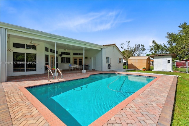 view of swimming pool with ceiling fan, a storage unit, and a patio