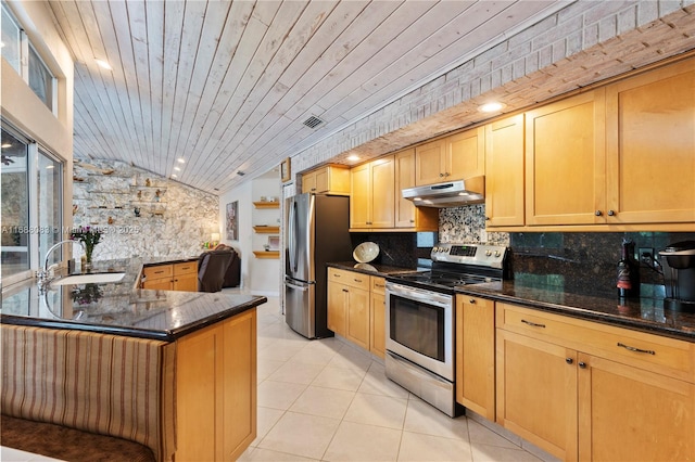 kitchen with dark stone counters, sink, decorative backsplash, appliances with stainless steel finishes, and kitchen peninsula