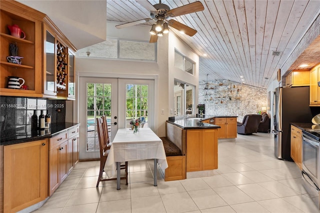 kitchen with french doors, wooden ceiling, stainless steel electric range, a breakfast bar area, and a kitchen island