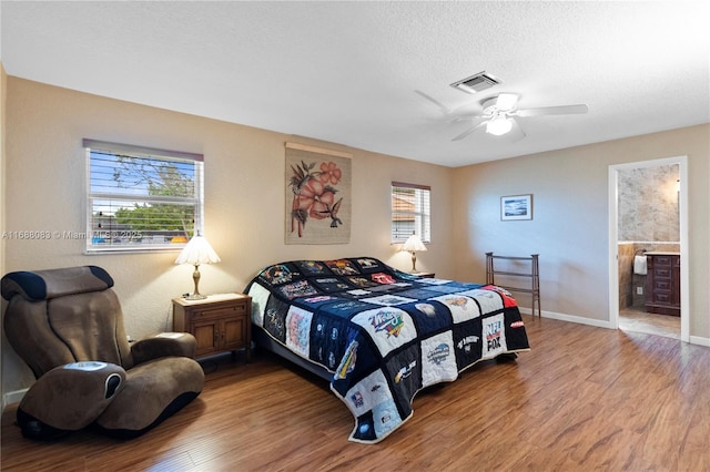 bedroom with wood-type flooring, a textured ceiling, ensuite bathroom, and ceiling fan