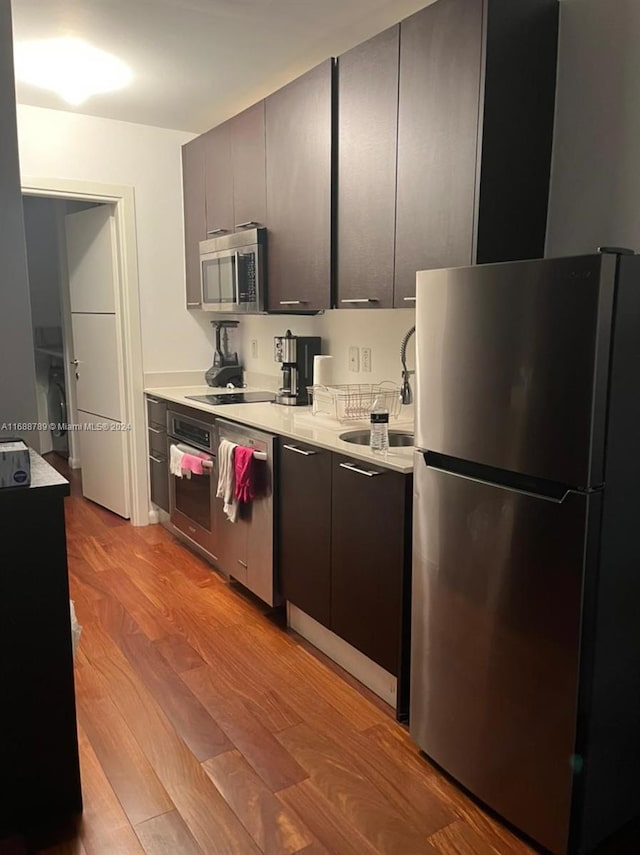 1560 Pennsylvania Ave Unit 213, Miami Beach, FL 33139 - kitchen featuring appliances with stainless steel finishes, light wood-style flooring, light countertops, and modern cabinets