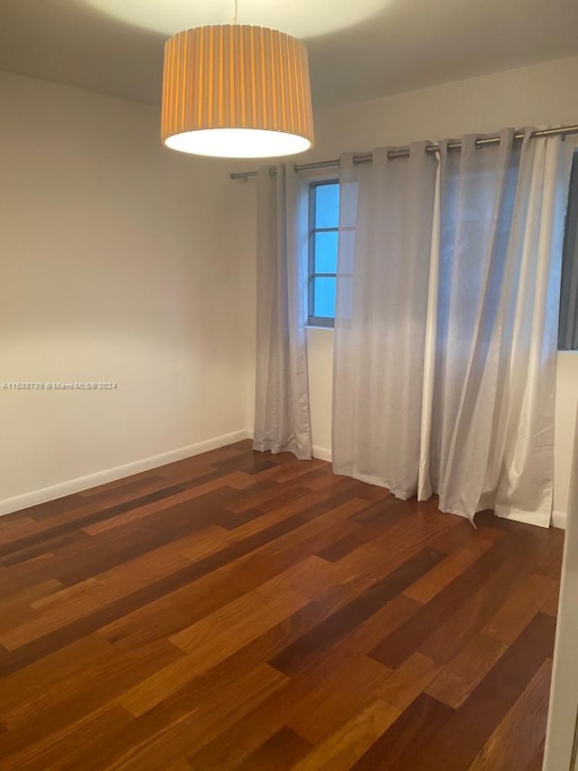 unfurnished room with dark hardwood / wood-style flooring