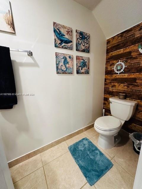 bathroom with toilet, lofted ceiling, and tile patterned floors