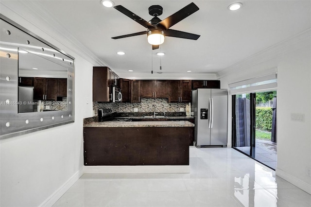 kitchen featuring sink, appliances with stainless steel finishes, ornamental molding, tasteful backsplash, and dark brown cabinets