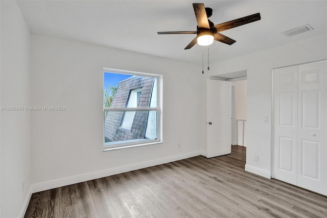 unfurnished bedroom featuring light hardwood / wood-style flooring, ceiling fan, and a closet