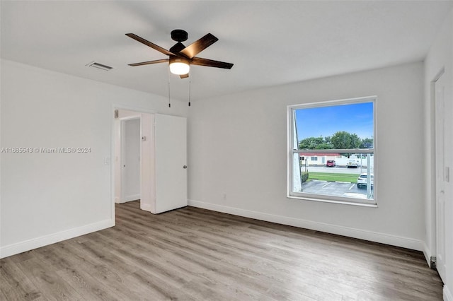 empty room with ceiling fan and light hardwood / wood-style floors