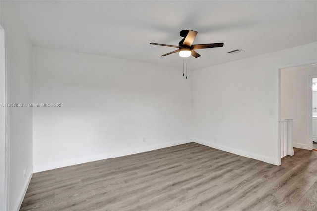 spare room with light wood-type flooring and ceiling fan