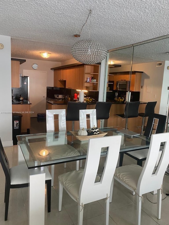 dining room featuring a textured ceiling and light tile patterned floors