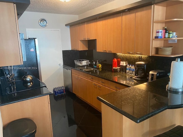 5401 Collins Ave Unit 412, Miami Beach, FL 33140 - kitchen with tasteful backsplash, dark tile patterned floors, dishwasher, a peninsula, and a textured ceiling