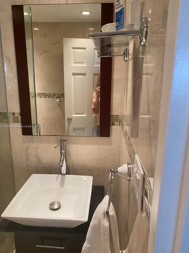 bathroom with tile walls, sink, and tasteful backsplash