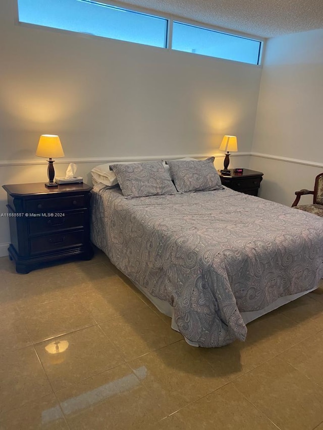 tiled bedroom with a textured ceiling