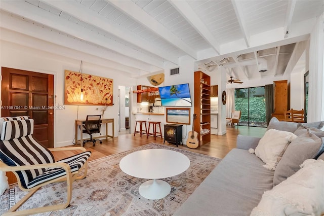 living room with hardwood / wood-style floors, beamed ceiling, and ceiling fan