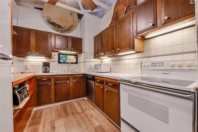 kitchen featuring decorative backsplash, light hardwood / wood-style flooring, sink, and white appliances