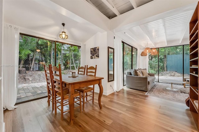 dining room with light hardwood / wood-style floors, wooden ceiling, and vaulted ceiling with beams