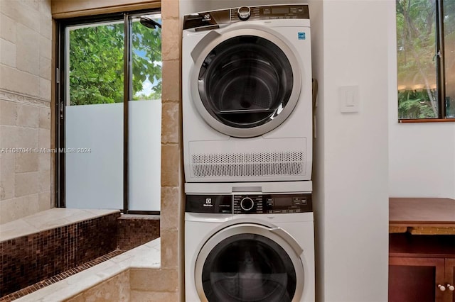 washroom with stacked washing maching and dryer