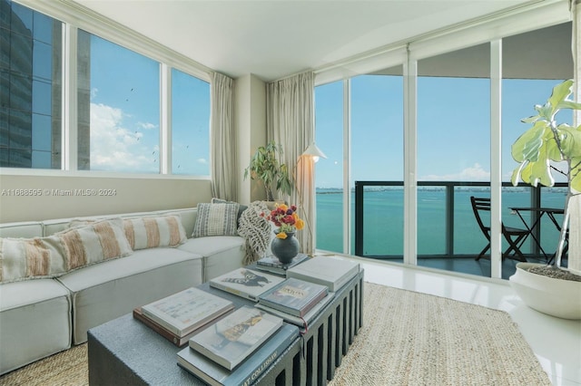 sunroom featuring a water view