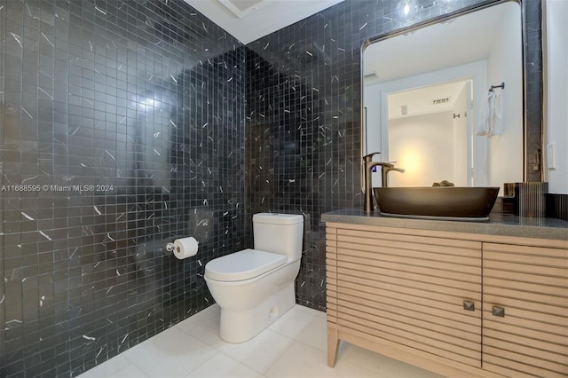 bathroom featuring toilet, vanity, tile walls, and tile patterned floors