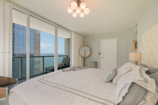 bedroom with access to exterior, expansive windows, and a water view