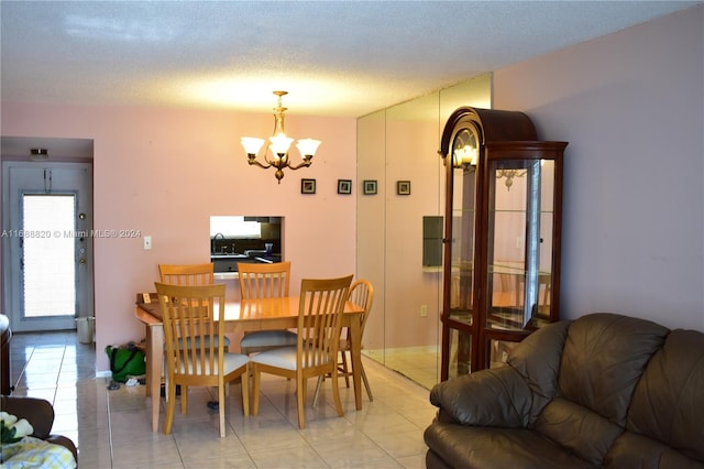 dining area featuring a chandelier, a textured ceiling, light tile patterned floors, and sink