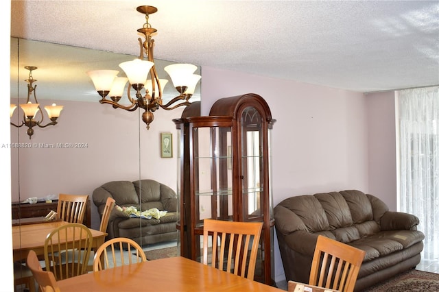 dining area featuring a notable chandelier and a textured ceiling