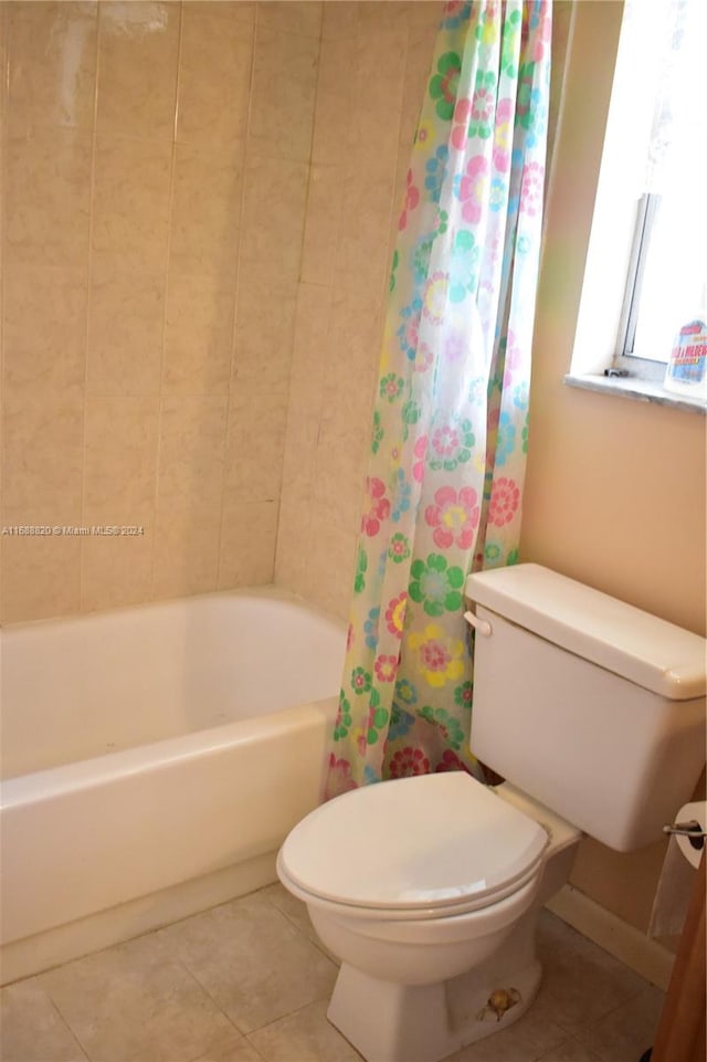 bathroom featuring toilet, shower / tub combo, and tile patterned floors