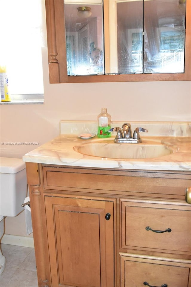 bathroom featuring tile patterned flooring, vanity, and toilet