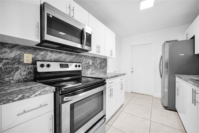 kitchen featuring white cabinetry, light tile patterned floors, backsplash, and appliances with stainless steel finishes