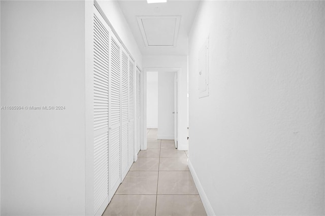 hallway featuring electric panel and light tile patterned flooring