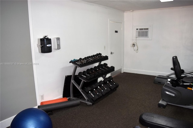 workout room featuring a wall mounted AC and carpet