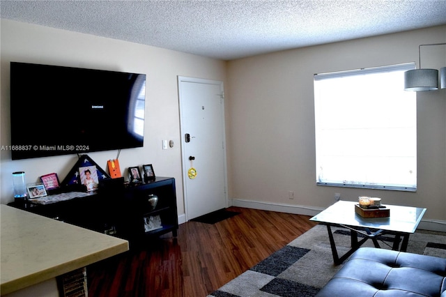 living room featuring a textured ceiling and dark hardwood / wood-style floors