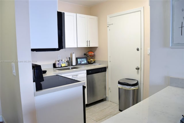 kitchen with stainless steel dishwasher, white cabinets, and sink