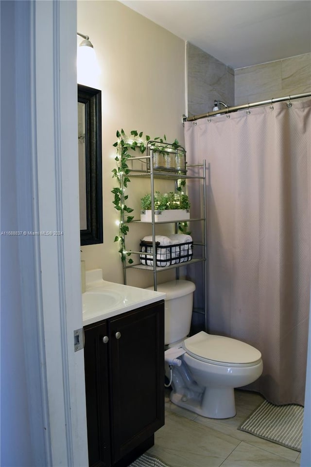 bathroom with toilet, vanity, and a shower with shower curtain