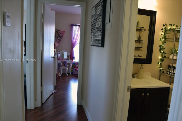 corridor with dark hardwood / wood-style floors and sink