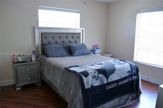 bedroom with multiple windows and dark hardwood / wood-style flooring